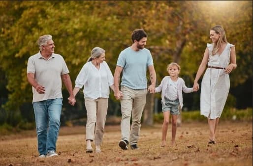 Family holding hands in a field, symbolizing unity and planning for the future in estate planning.