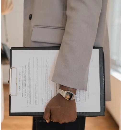 Man holding a Last Will and Testament at a desk, representing the legal process of determining who can get a copy of a will.
