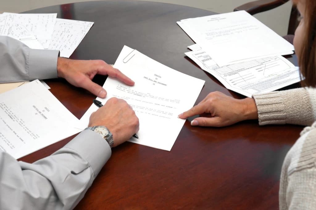 Signing-paperwork-for-a-designated-beneficiary Man and Woman Signing Paperwork