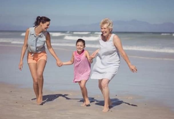 Family-holding-hands Three generations of women happily holding hands at beach