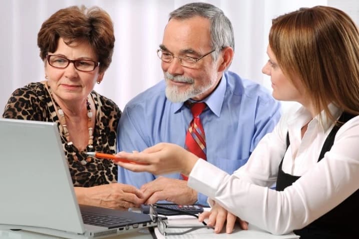 Couple-writing-a-Living-Will-with-Attorney Couple learning benefits of a revocable trust .