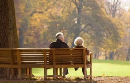 Preparing for a Funeral Older couple sitting on bench in park discussing preparing for a funeral