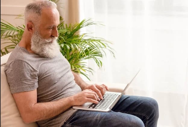 Man-learning-how-to-write-a-testament-online Man using a step by step online guide on how to write a testament